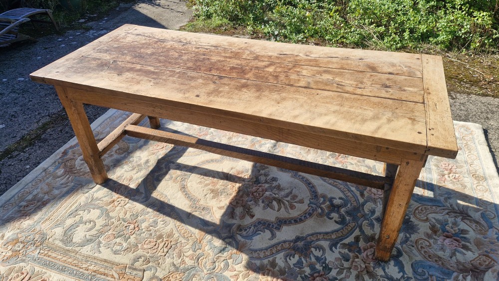 A rustic French farmhouse dining table made of weathered oak with a heavy plank top and sturdy stretcher base. View VI