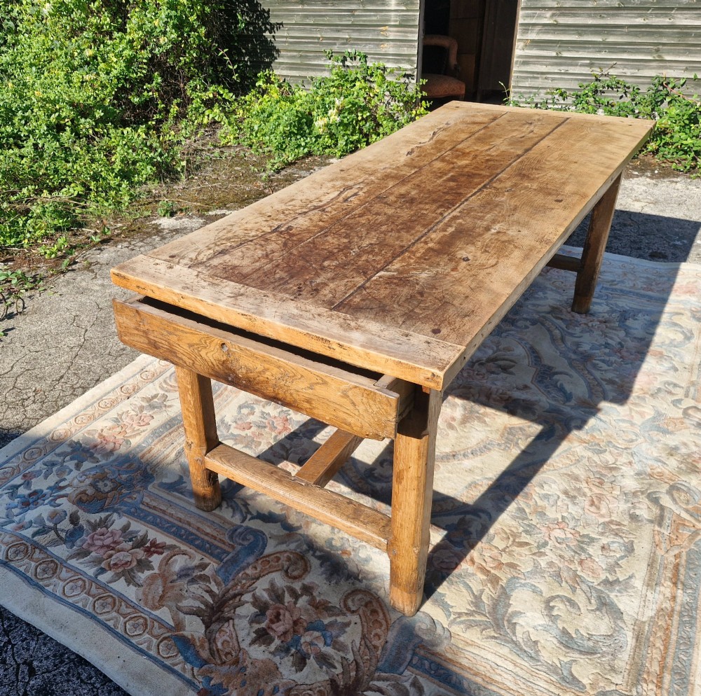 A rustic French farmhouse dining table made of weathered oak with a heavy plank top and sturdy stretcher base. View VII