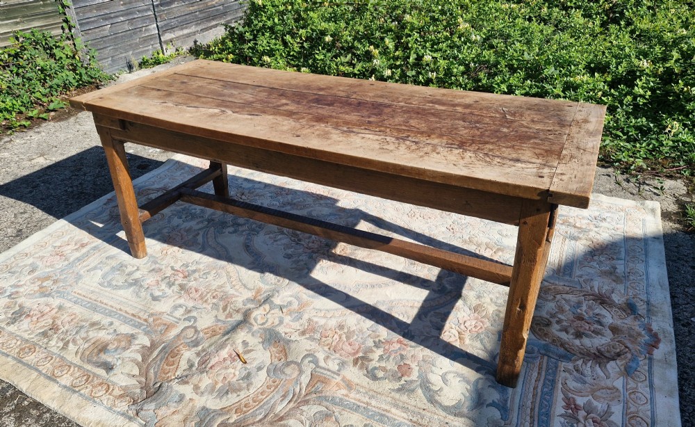 A rustic French farmhouse dining table made of weathered oak with a heavy plank top and sturdy stretcher base. View VIII