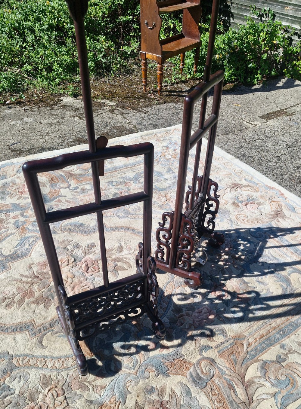 A pair of dark carved hardwood Chinese adjustable standard lamps featuring openwork bases and slender vertical shafts. View II