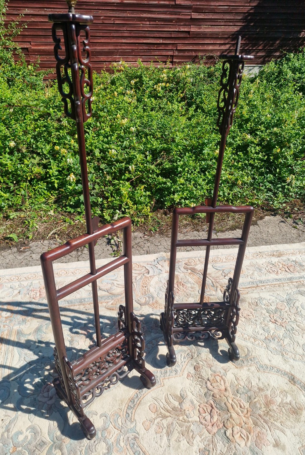 A pair of dark carved hardwood Chinese adjustable standard lamps featuring openwork bases and slender vertical shafts. View V