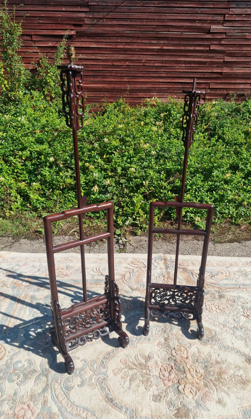 A pair of dark carved hardwood Chinese adjustable standard lamps featuring openwork bases and slender vertical shafts. View VI