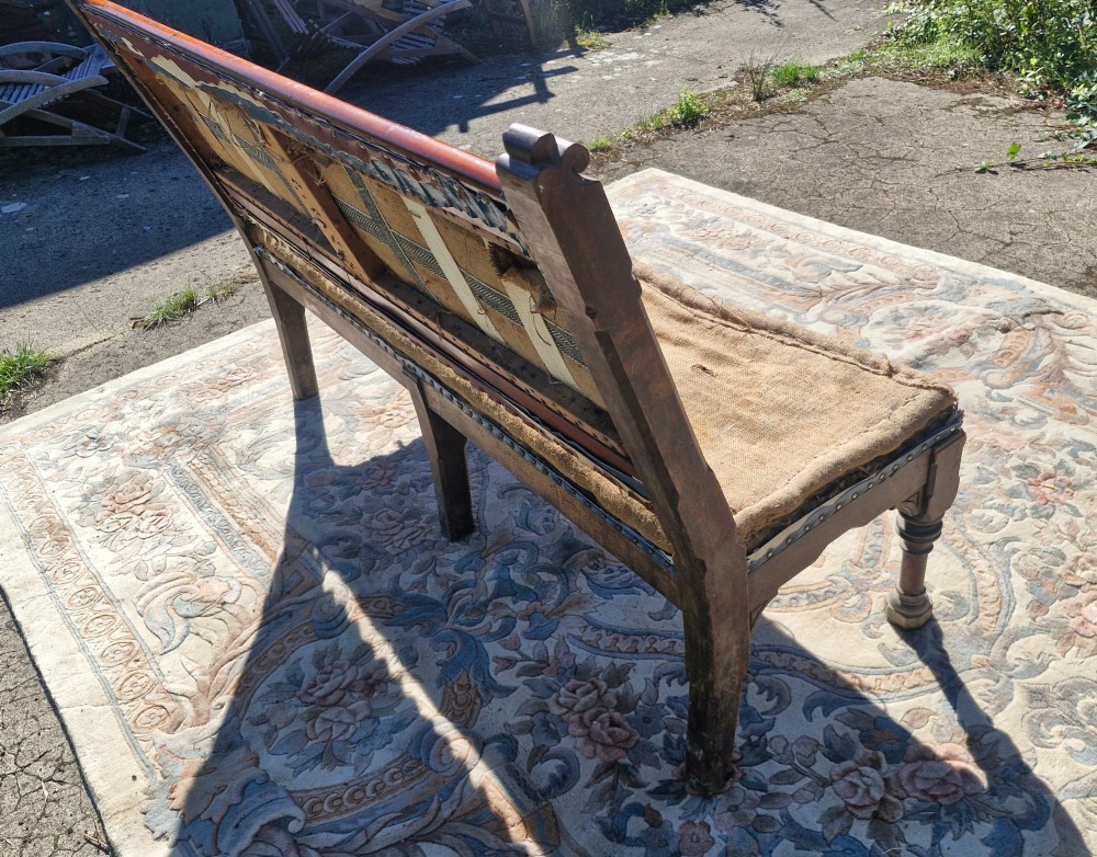 A Victorian mahogany hall bench featuring a padded backrest and seat upholstered in hessian cloth, supported by turned front legs and carved wooden trim. View II