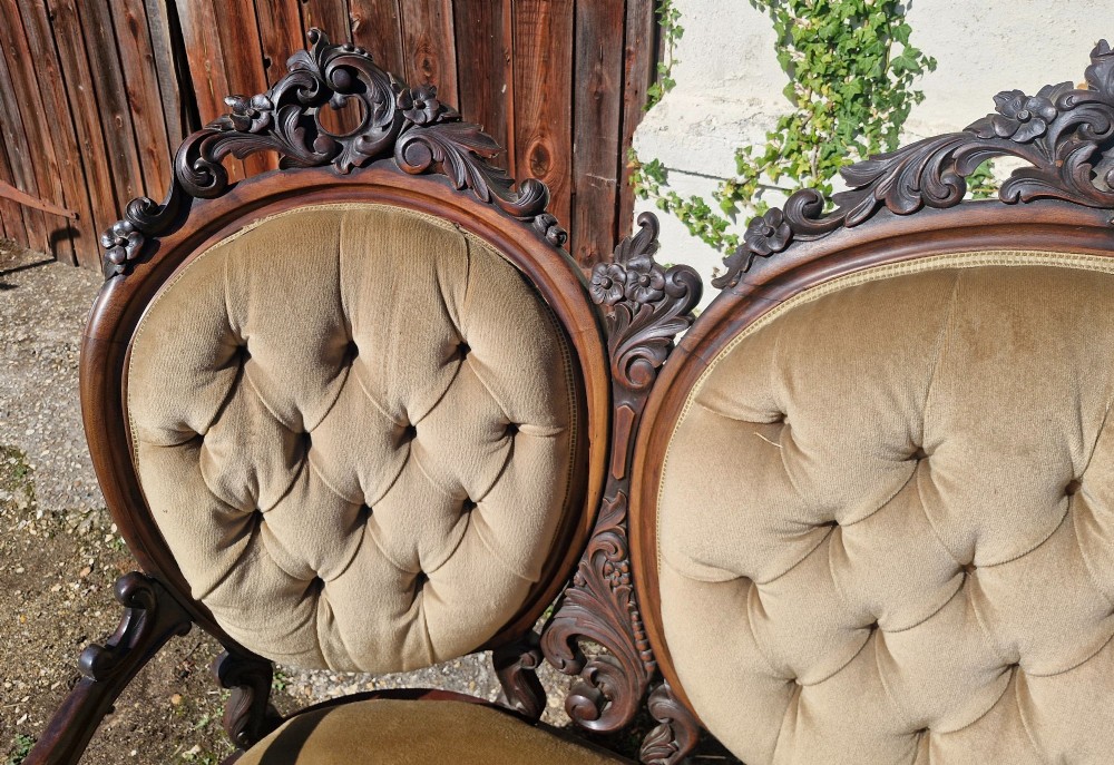 A 19th-century mahogany conversation sofa featuring three oval button-back upholstered panels, intricate carved frame detailing, cabriole legs, and velvet seating. View II