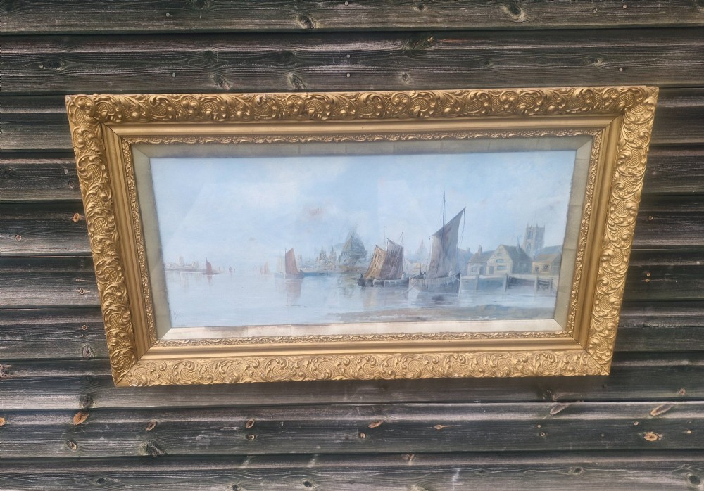 A wide horizontal oil painting depicting sailing barges on the River Thames, enclosed within an ornate gilded frame.