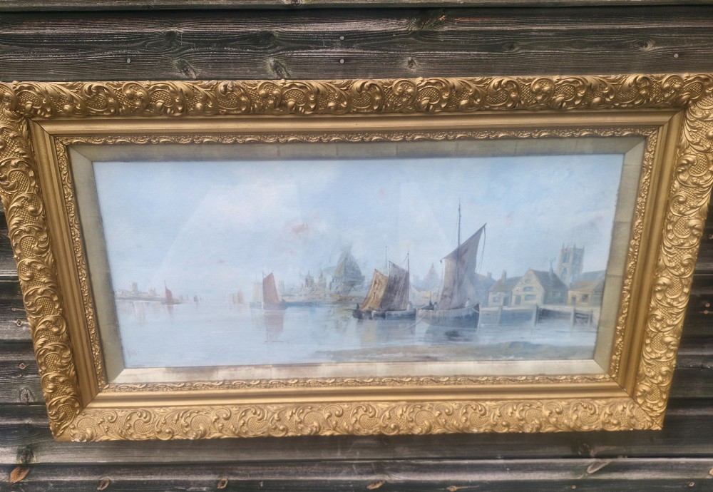 A wide horizontal oil painting depicting sailing barges on the River Thames, enclosed within an ornate gilded frame. View III