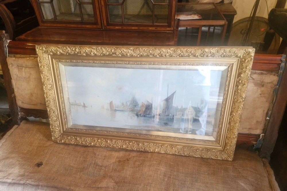 A wide horizontal oil painting depicting sailing barges on the River Thames, enclosed within an ornate gilded frame. View IV