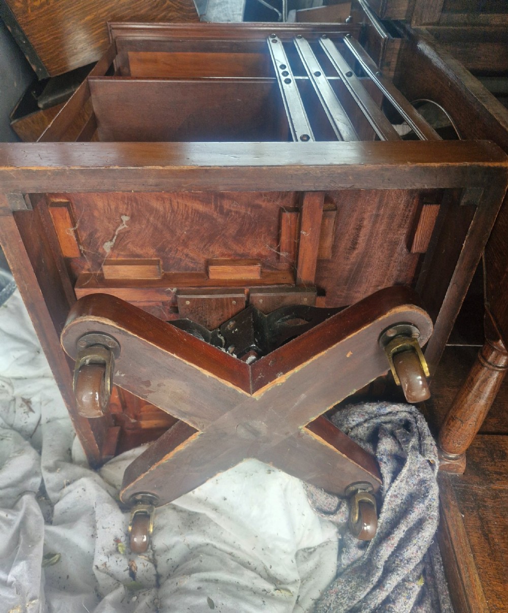 A late Victorian mahogany revolving bookcase featuring two square open tiers with vertical slatted sides fixed by brass studs. View II