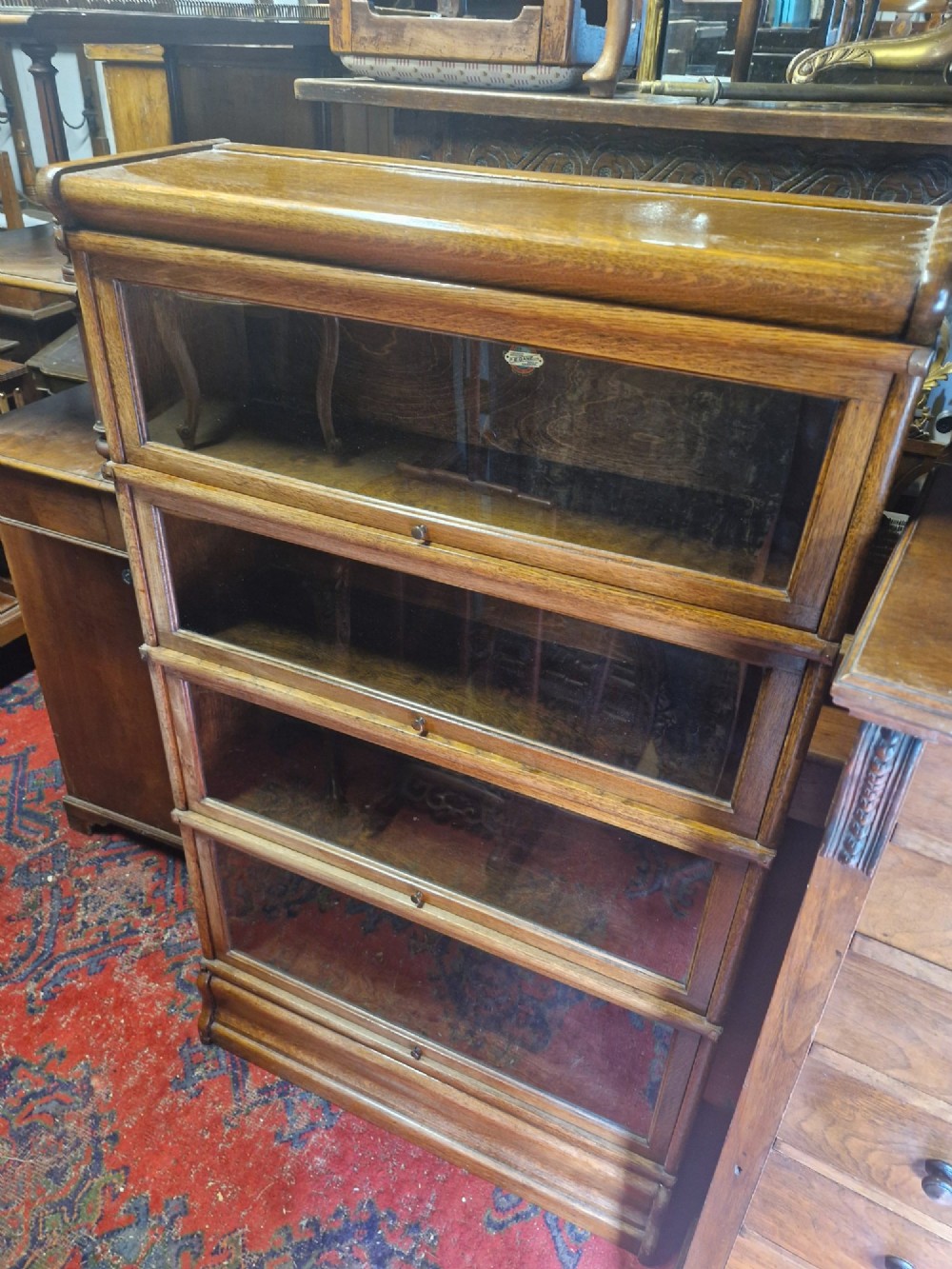 A four-tier oak barrister sectional bookcase featuring individual glazed doors that lift and retract. View IV