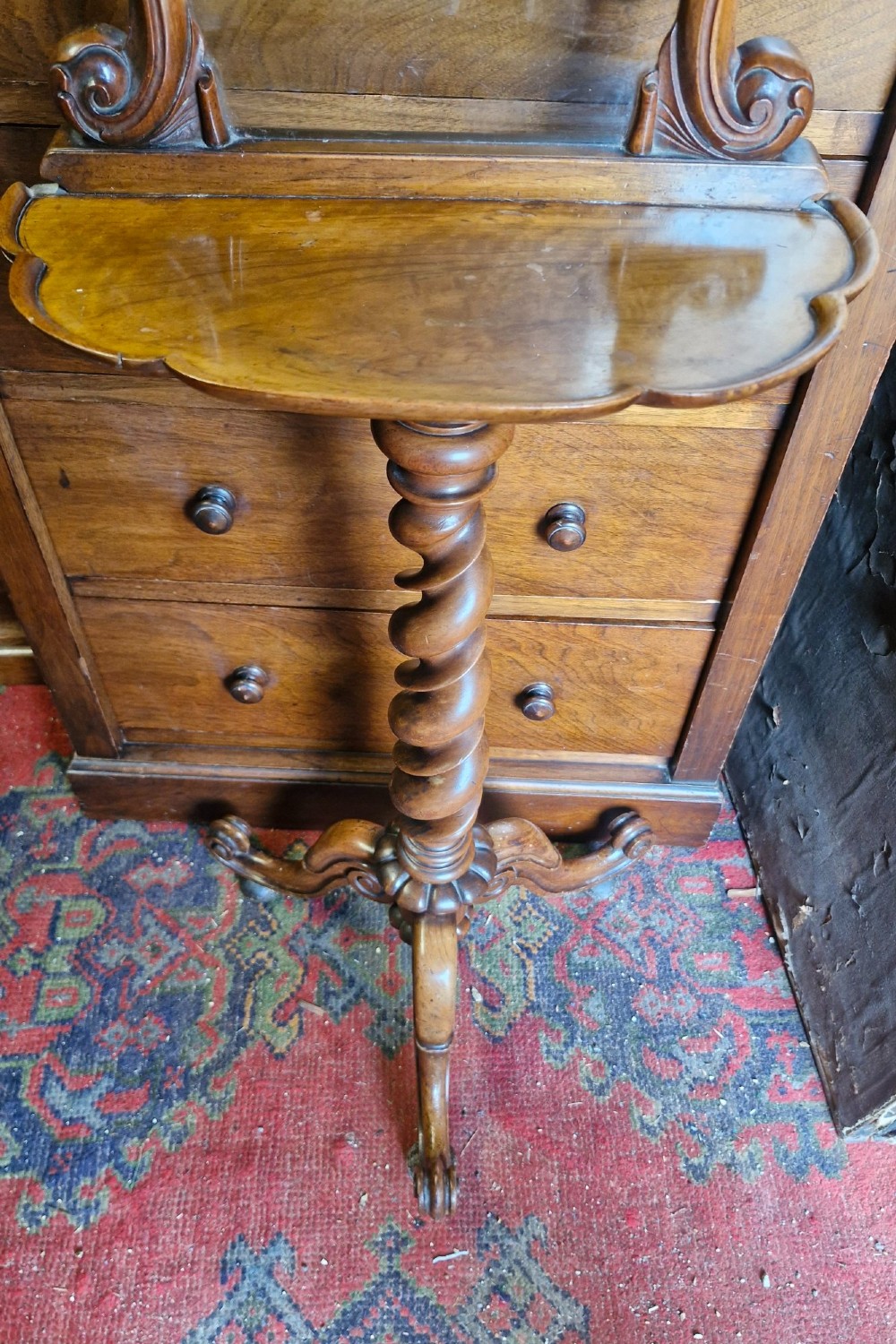 A Victorian walnut pedestal table featuring a shaped tabletop, an ornate carved mirror frame back, a spiral barley twist column, and carved tripod legs. View II
