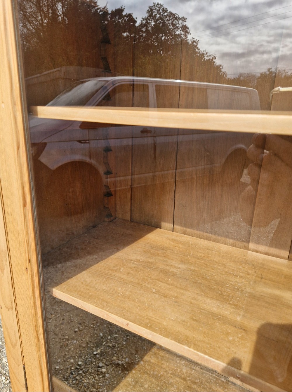 An early Victorian pine glazed bookcase featuring arched glass upper doors above a lower two-door cupboard base. View V