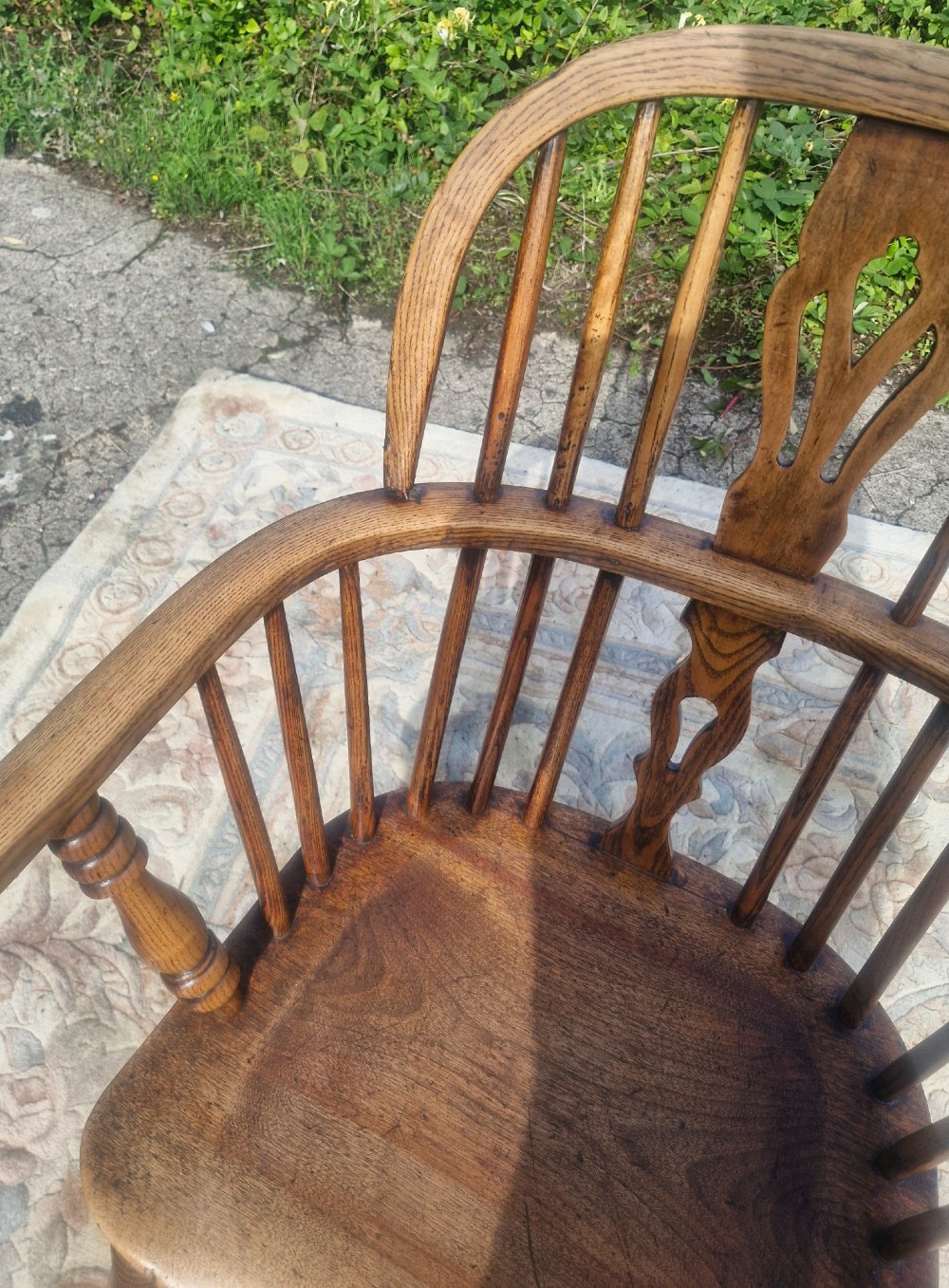 A Victorian wooden Windsor armchair with a bow back, turned spindles, a pierced central splat, integrated armrests, and a contoured saddle seat on turned legs. View IV