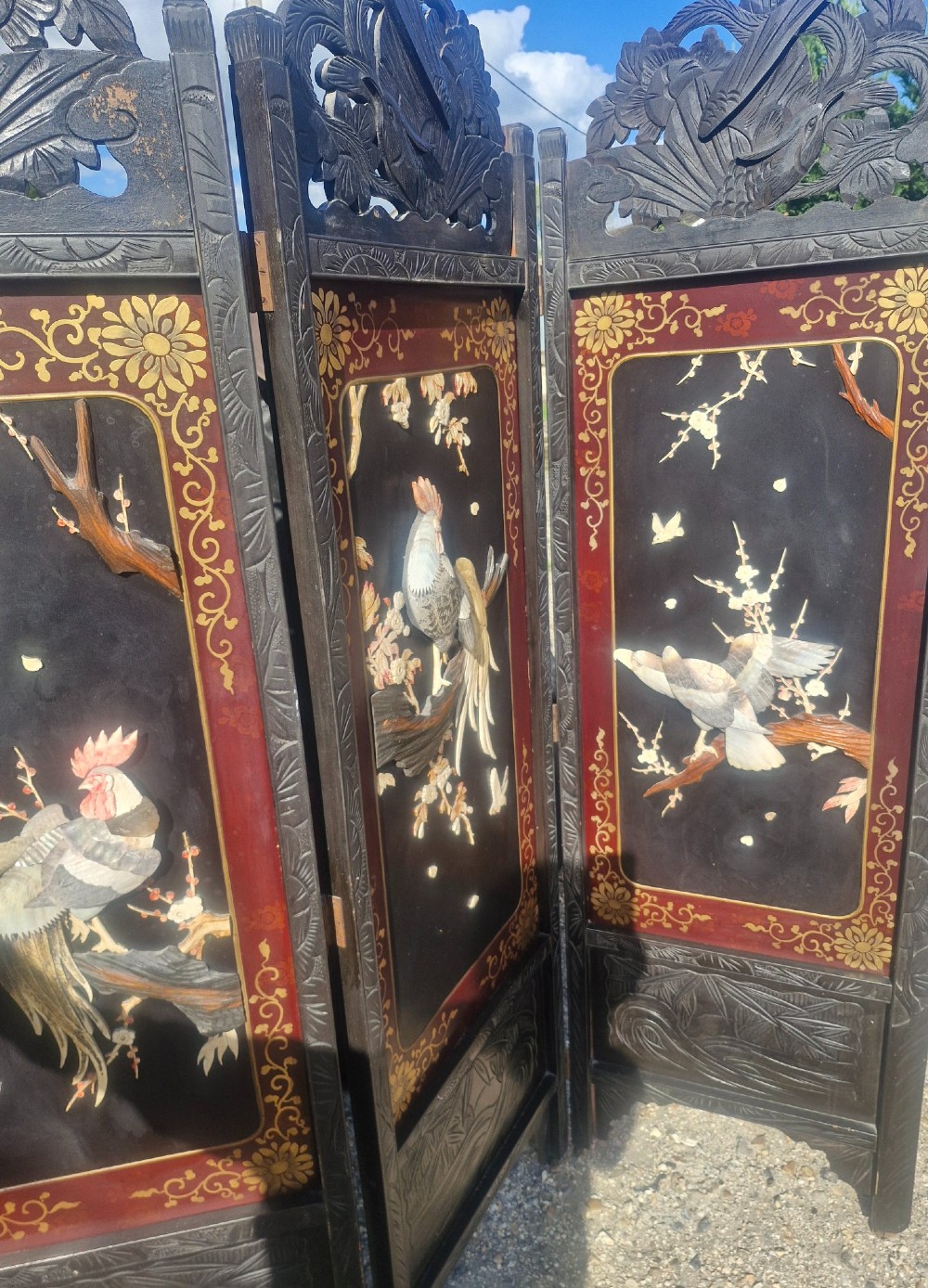 A four-panel dark wood folding screen featuring carved openwork top crests and central dark panels with raised bone inlays depicting birds among flowering branches. View VI