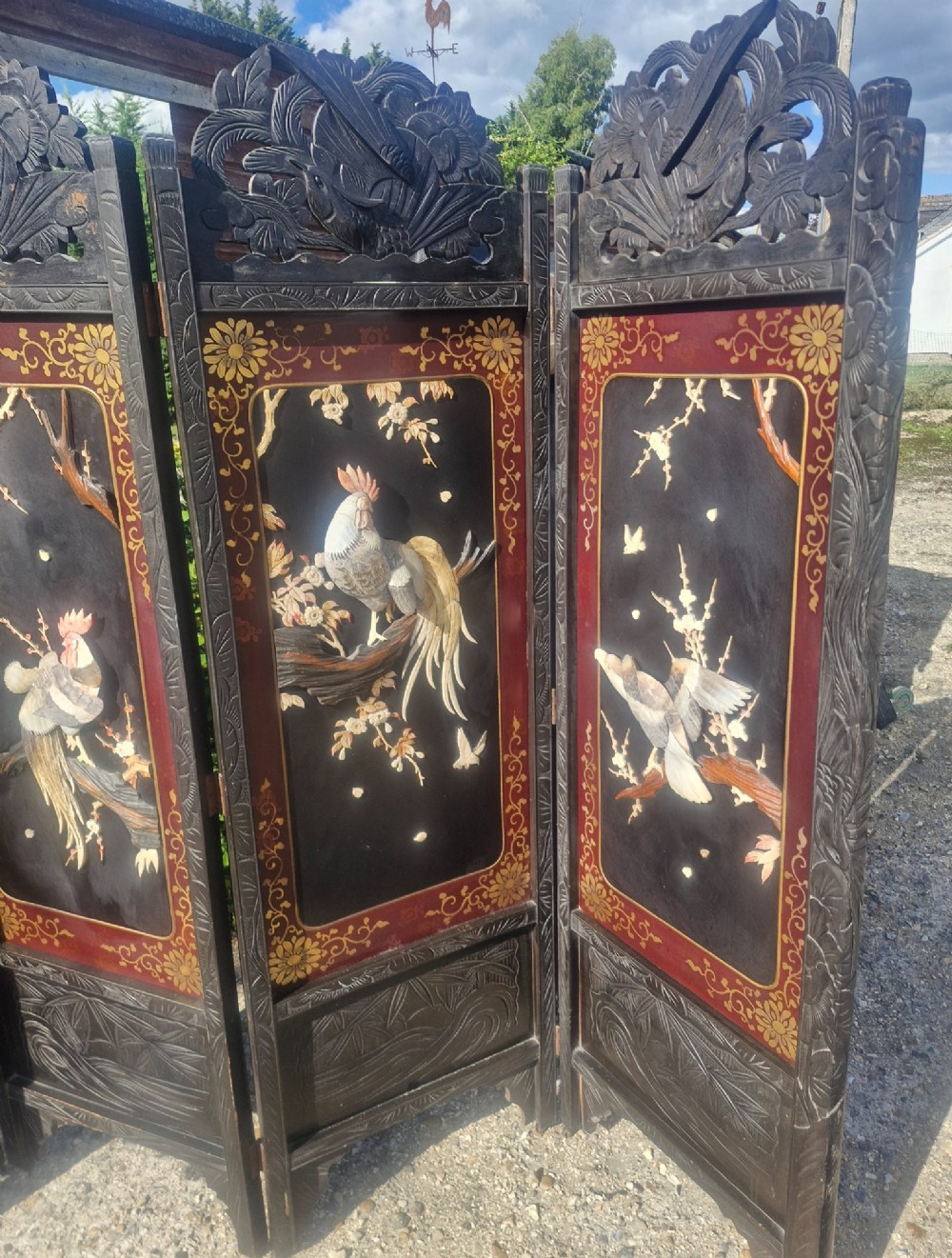 A four-panel dark wood folding screen featuring carved openwork top crests and central dark panels with raised bone inlays depicting birds among flowering branches. View X