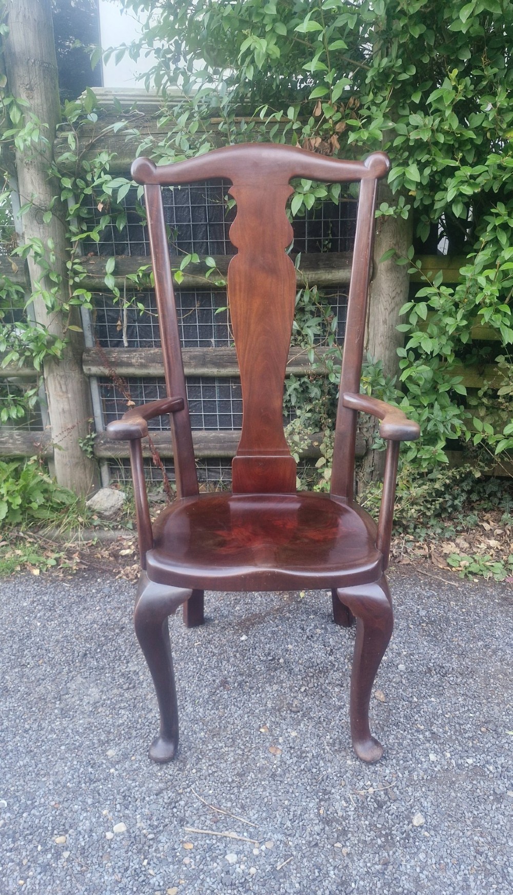 A high-backed solid mahogany armchair featuring a contoured vasiform splat back, shaped armrests, solid timber seat, and cabriole front legs.