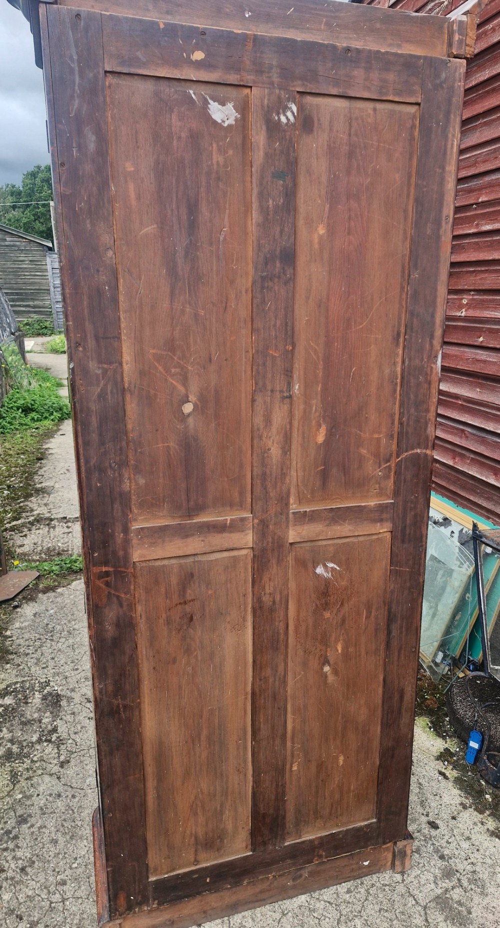 A tall Victorian mahogany bookcase cabinet featuring two arched glazed doors revealing adjustable interior shelving atop a solid plinth base. View III