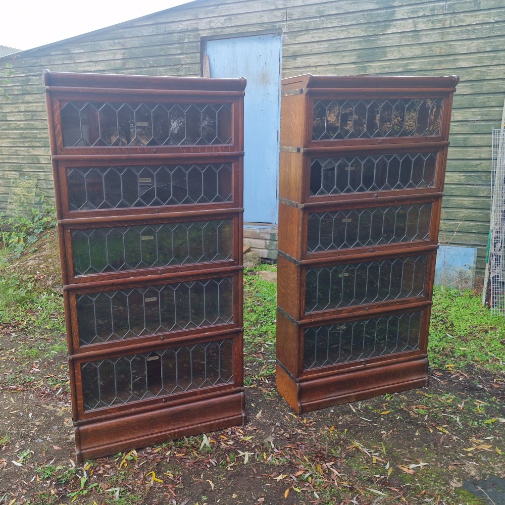 A pair of matching five-tier oak Globe Wernicke sectional bookcases featuring leaded glazed lift-up glass doors. View II