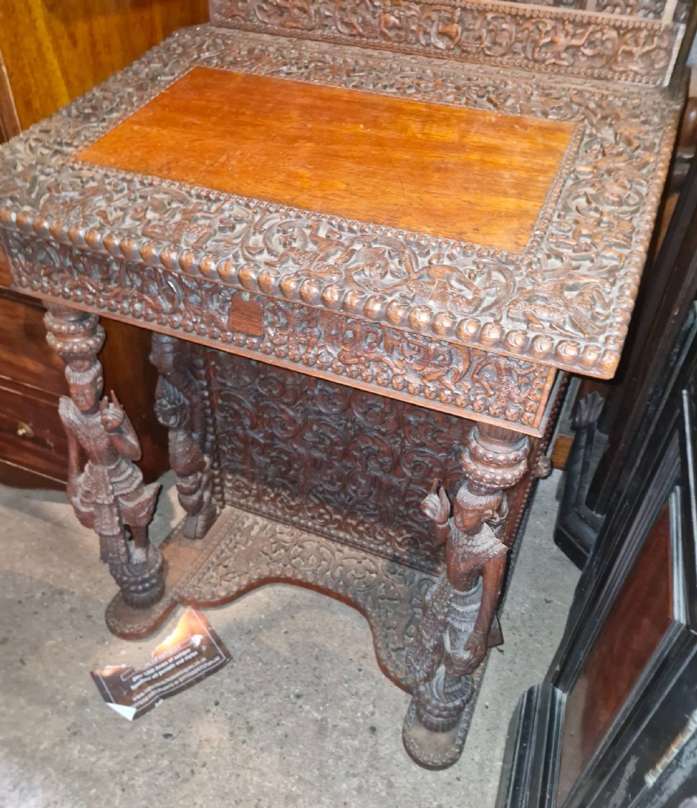 A dark hardwood Davenport writing desk featuring high-relief foliate carvings, figural supports, and a sloped writing lid. View XIV