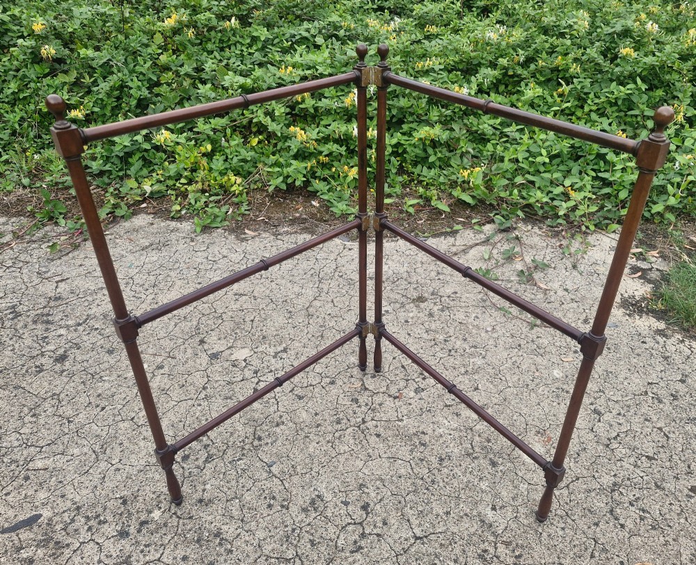 A freestanding mahogany folding towel rail with turned wooden finials and multiple horizontal crossbars on hinged upright supports. View II