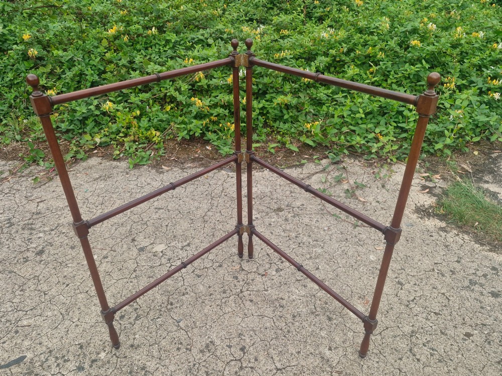 A freestanding mahogany folding towel rail with turned wooden finials and multiple horizontal crossbars on hinged upright supports. View III
