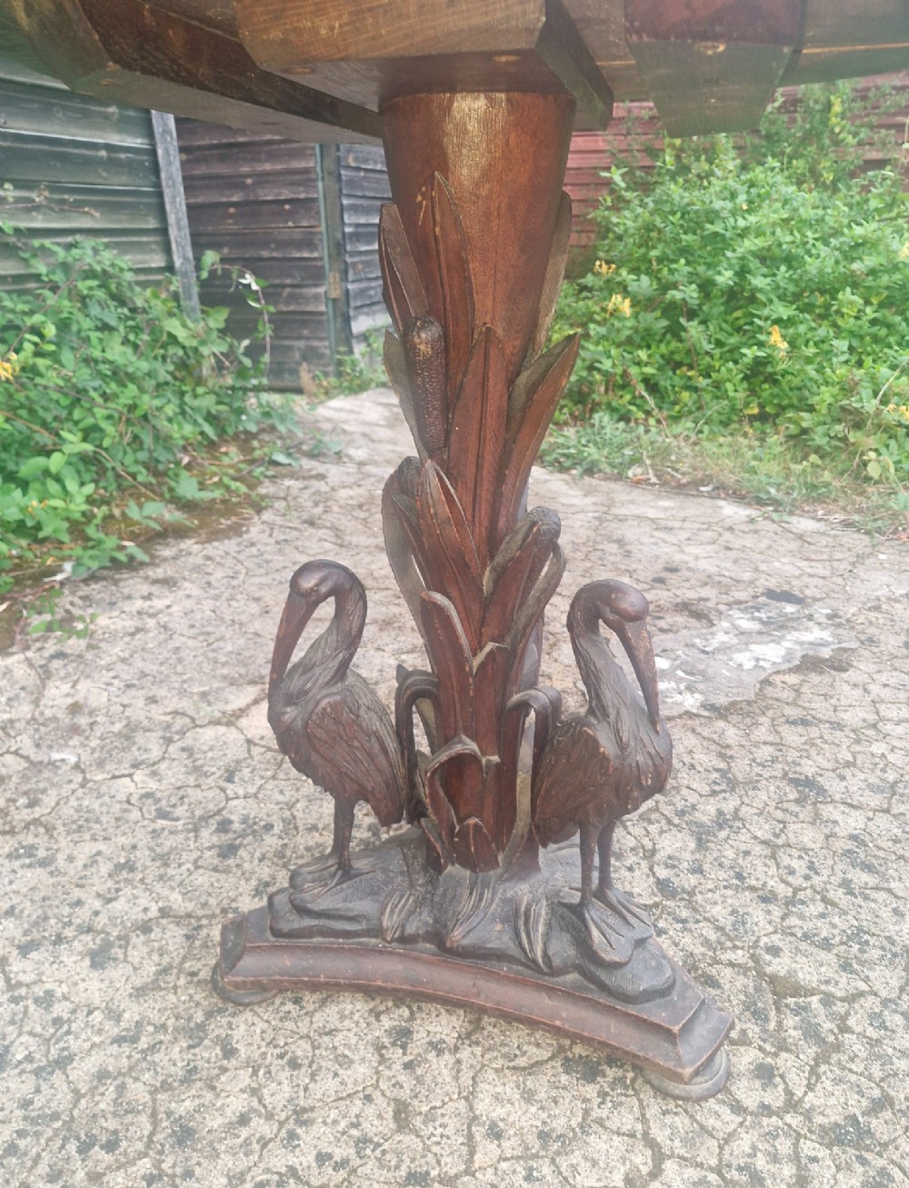 A Victorian carved oak occasional table featuring sculpted wading birds encircling a central pedestal above a triform base. View II