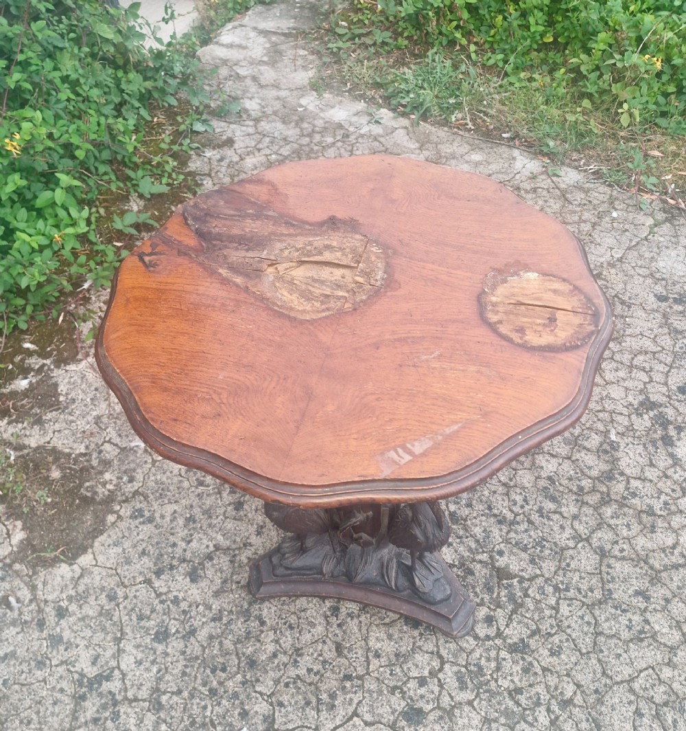A Victorian carved oak occasional table featuring sculpted wading birds encircling a central pedestal above a triform base. View III