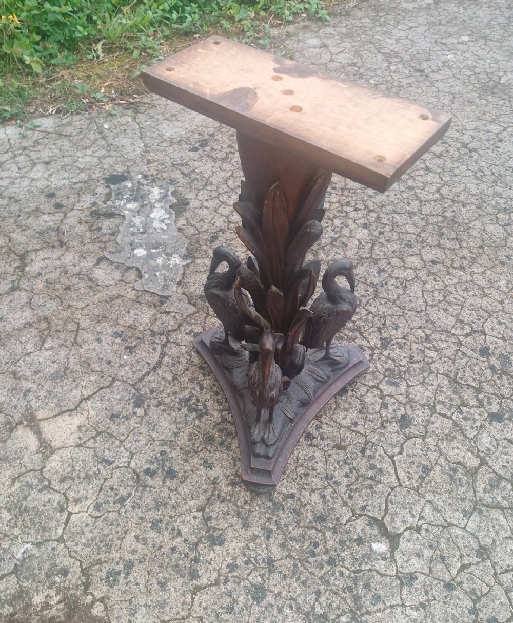A Victorian carved oak occasional table featuring sculpted wading birds encircling a central pedestal above a triform base. View IV