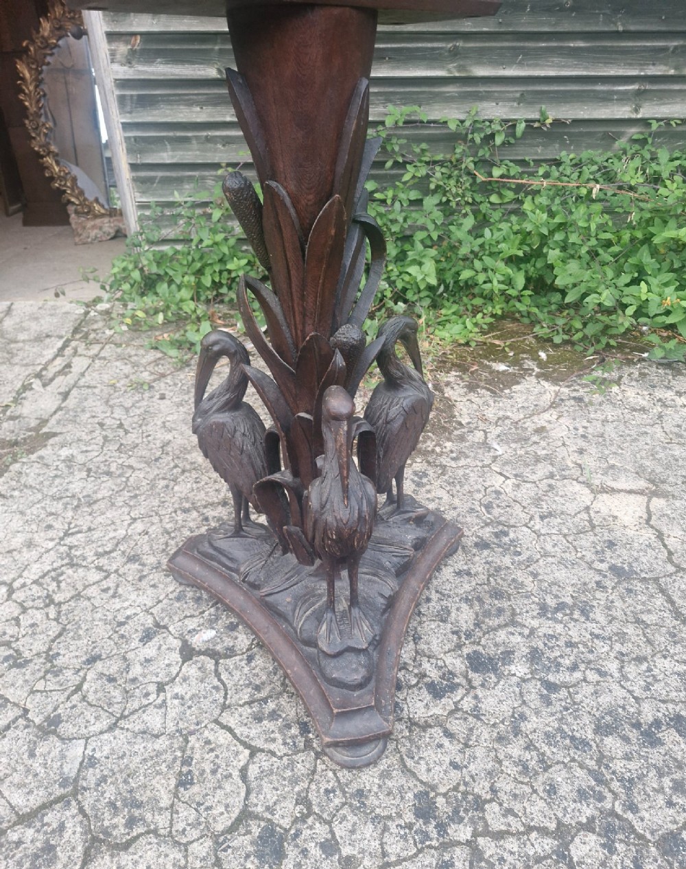 A Victorian carved oak occasional table featuring sculpted wading birds encircling a central pedestal above a triform base. View VII