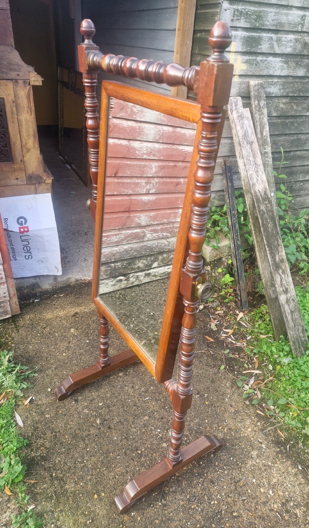 A 19th-century dark mahogany cheval dressing mirror featuring turned upright supports, finials, a rectangular tilting glass, and splayed trestle feet. View II