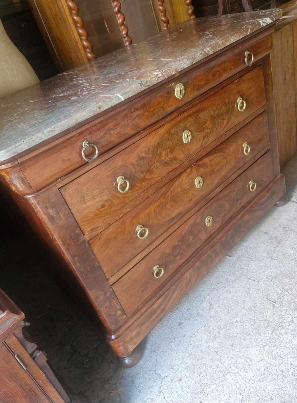A nineteenth-century French mahogany chest of drawers featuring four drawers with brass ring pulls, escutcheons, and a grey veined marble top. View III
