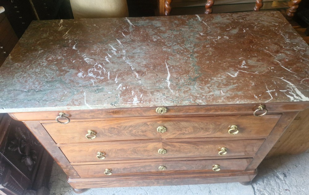 A nineteenth-century French mahogany chest of drawers featuring four drawers with brass ring pulls, escutcheons, and a grey veined marble top. View V