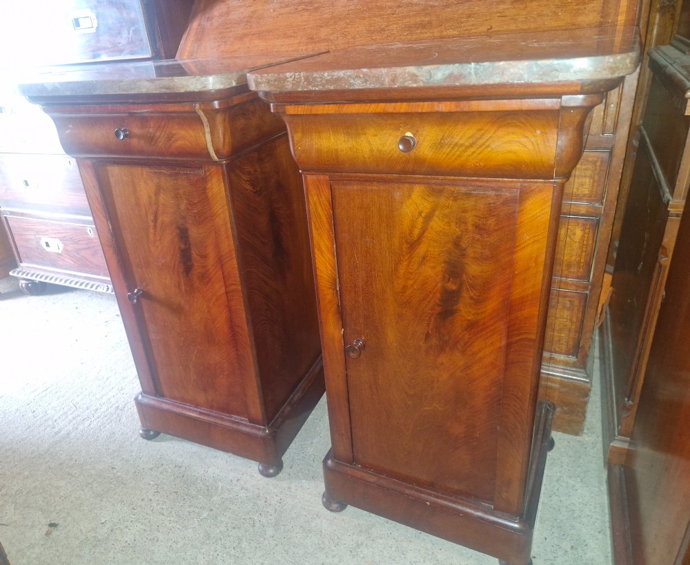 A pair of French mahogany bedside cabinets with reddish brown marble tops, upper drawers, and single panelled doors. View VII