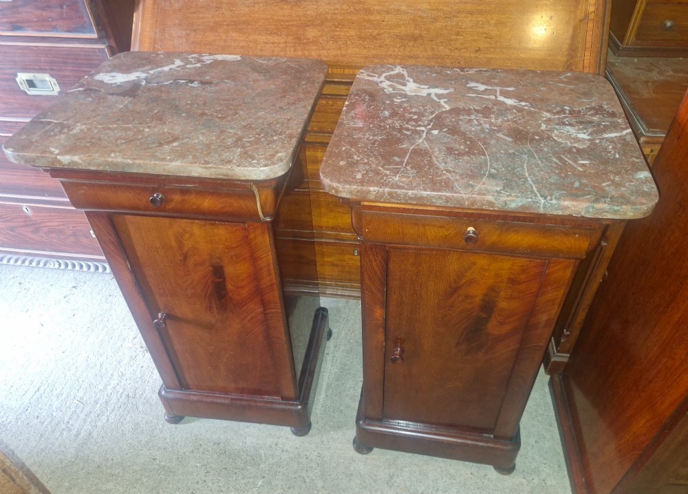 A pair of French mahogany bedside cabinets with reddish brown marble tops, upper drawers, and single panelled doors. View VIII