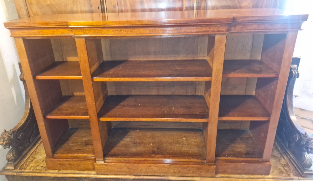 A mid-19th-century mahogany open-front bookcase featuring a three-bay breakfront design and adjustable shelves set on a solid plinth base.
