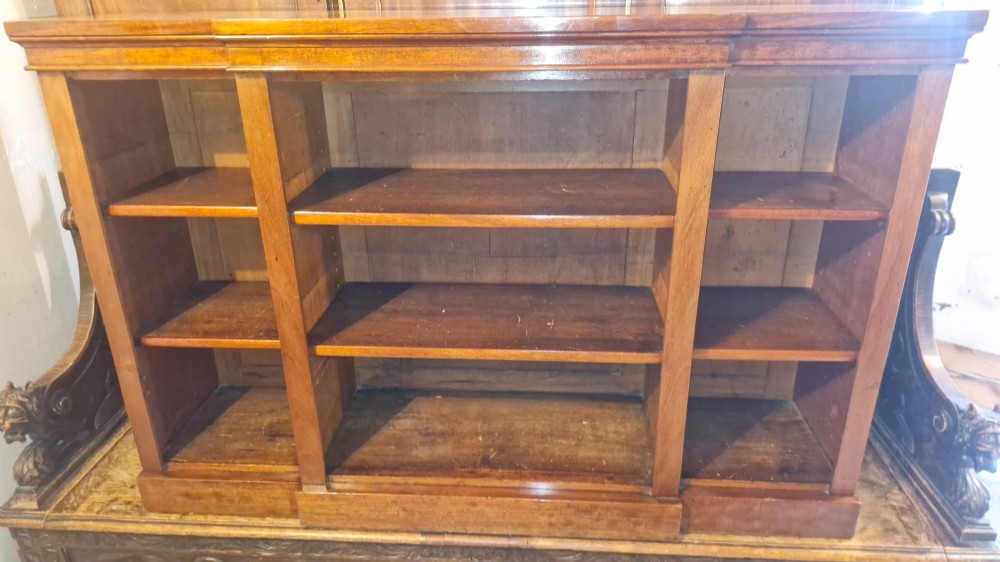 A mid-19th-century mahogany open-front bookcase featuring a three-bay breakfront design and adjustable shelves set on a solid plinth base. View V