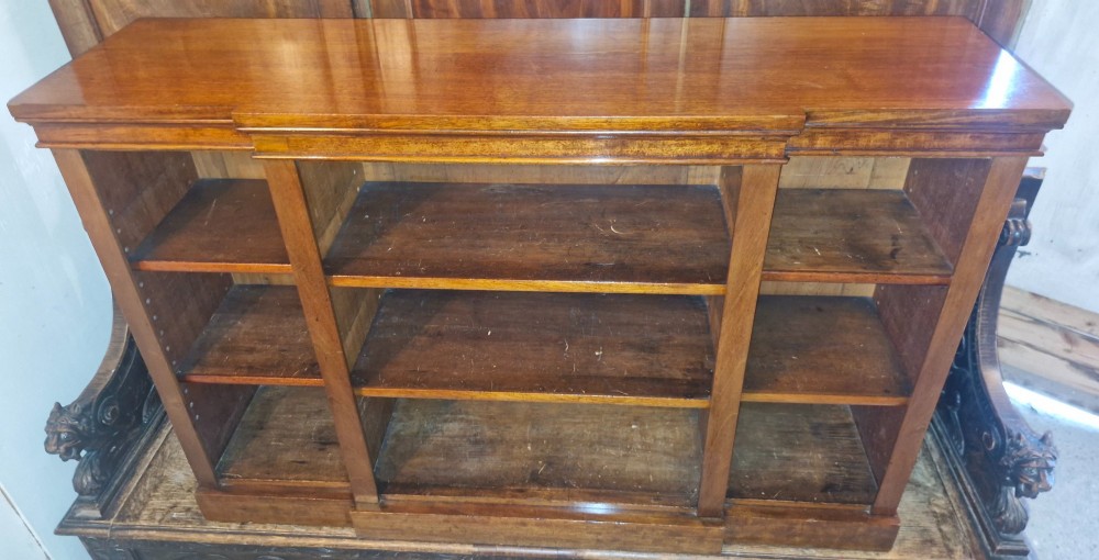 A mid-19th-century mahogany open-front bookcase featuring a three-bay breakfront design and adjustable shelves set on a solid plinth base. View VI
