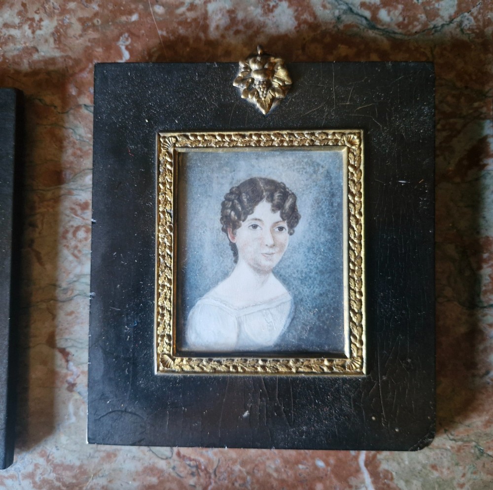 A set of five 19th-century antique portrait miniatures painted on papercard, displayed in dark ebonised frames with brass bezel rims. View IV