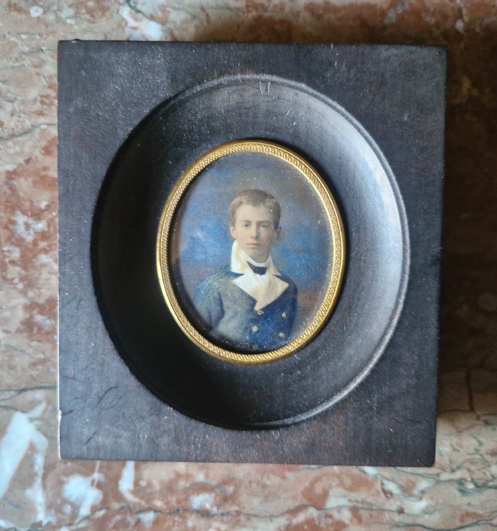 A set of five 19th-century antique portrait miniatures painted on papercard, displayed in dark ebonised frames with brass bezel rims. View V