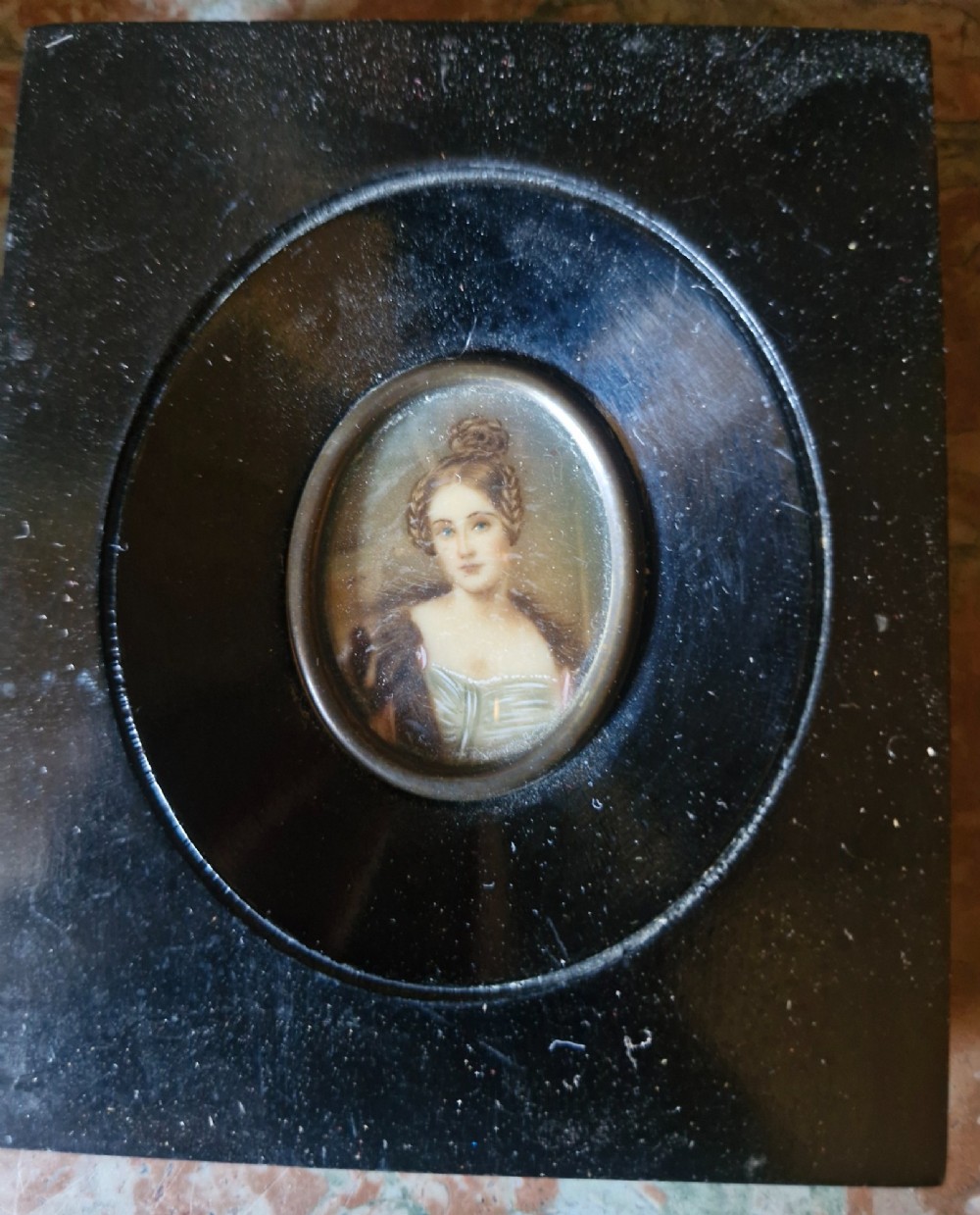 A set of five 19th-century antique portrait miniatures painted on papercard, displayed in dark ebonised frames with brass bezel rims. View X