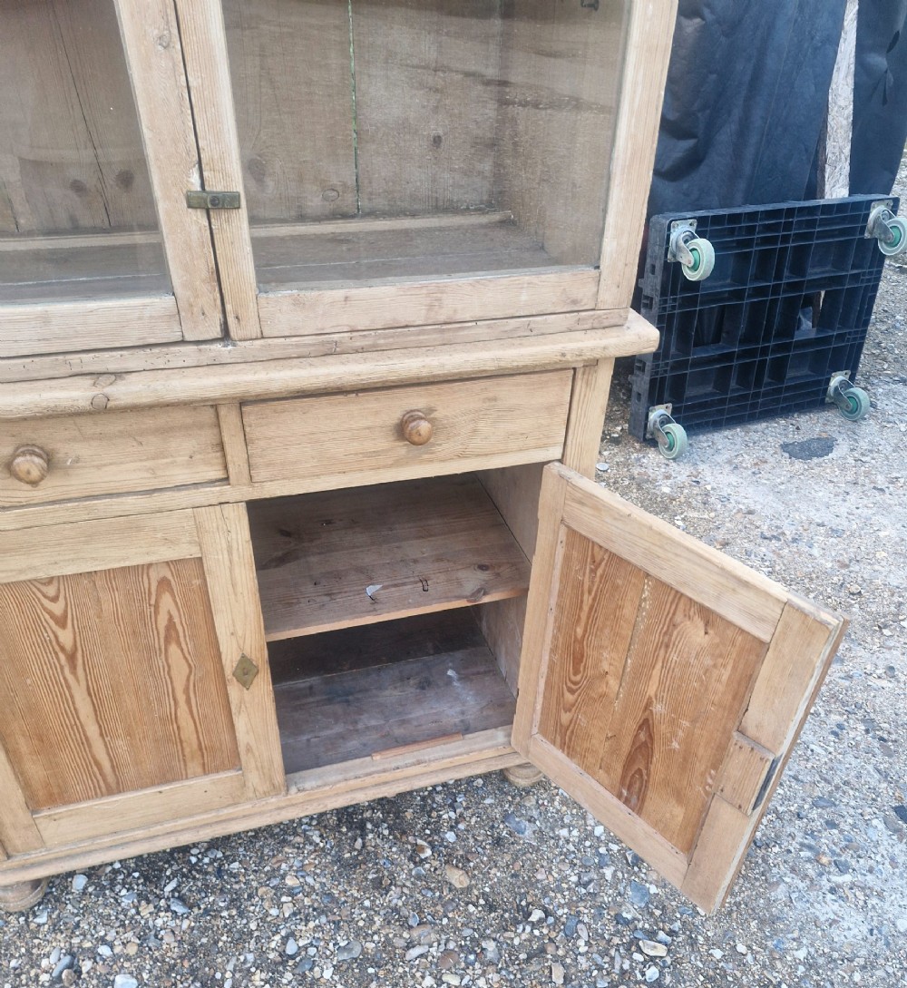 An antique two-part pine kitchen cupboard featuring an upper glazed cabinet with two shelves and a lower base with two drawers above panelled doors. View II