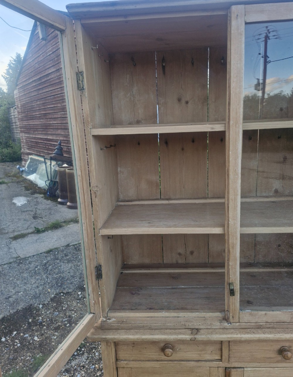 An antique two-part pine kitchen cupboard featuring an upper glazed cabinet with two shelves and a lower base with two drawers above panelled doors. View III