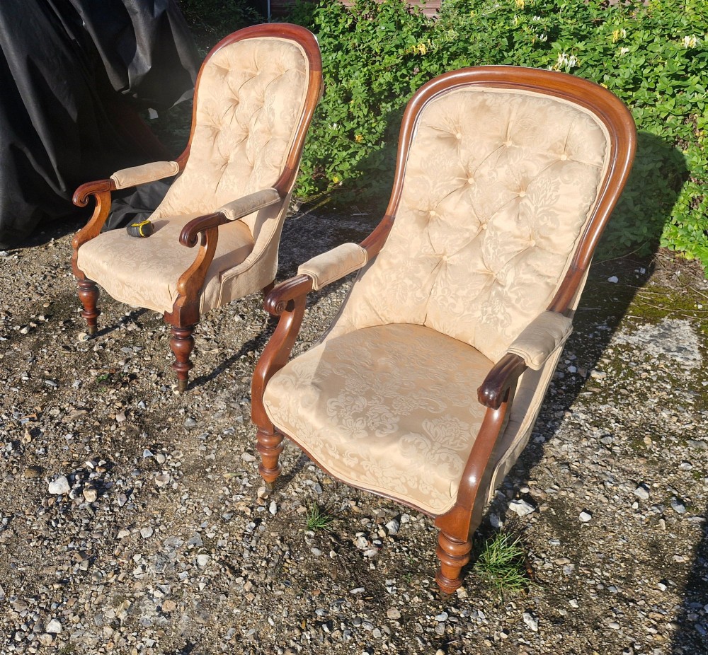 Victorian mahogany library armchair upholstered in gold damask fabric featuring a button-tufted back, scrolled armrests, and turned legs with brass castors. View V