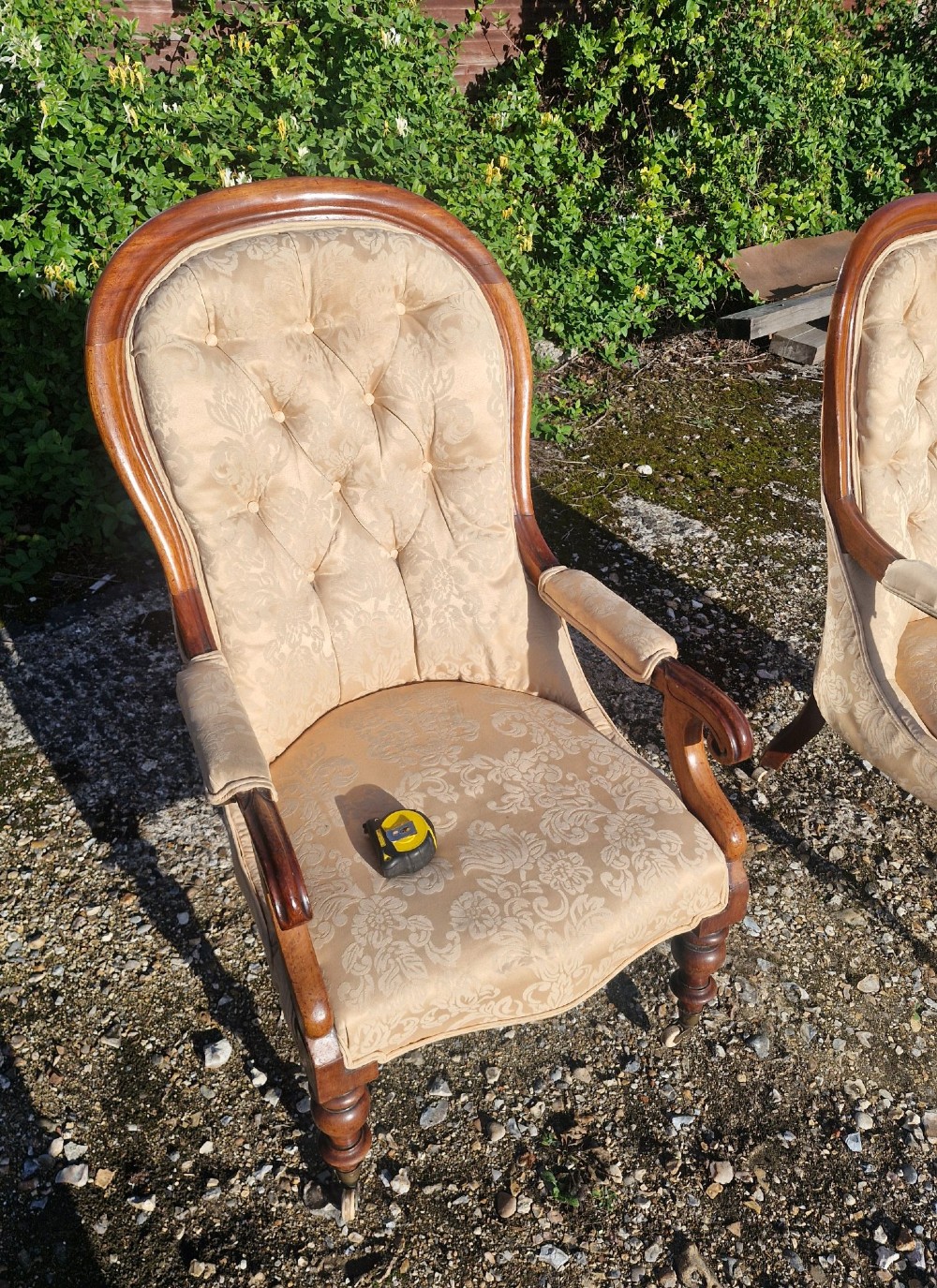 Victorian mahogany library armchair upholstered in gold damask fabric featuring a button-tufted back, scrolled armrests, and turned legs with brass castors. View VII