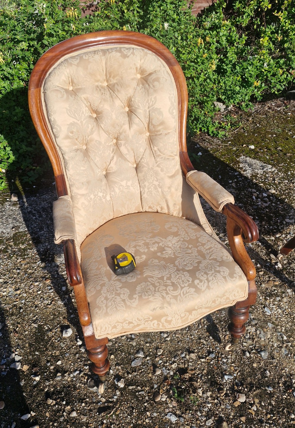 Victorian mahogany library armchair upholstered in gold damask fabric featuring a button-tufted back, scrolled armrests, and turned legs with brass castors. View VIII