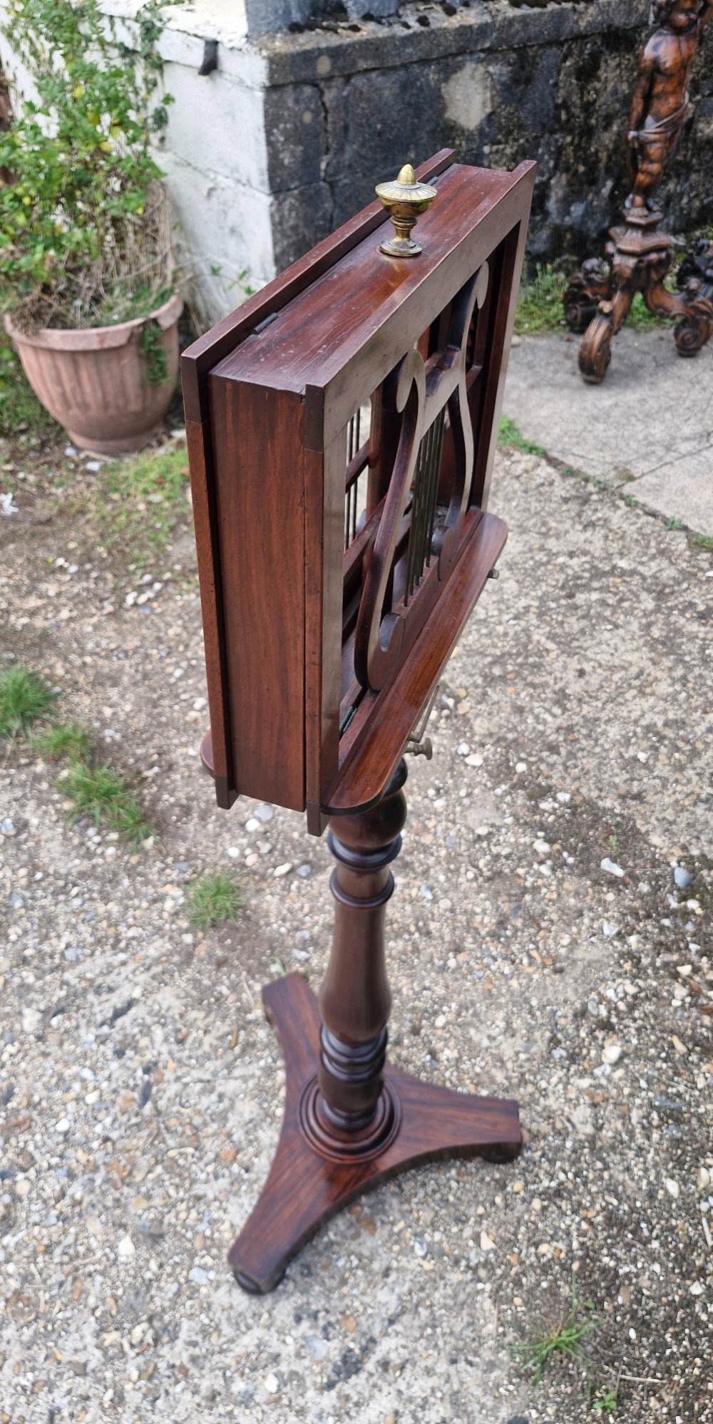 An early Victorian double-sided dark wood duet music stand featuring lyre-shaped rests and a turned pedestal column on a triform base. View II