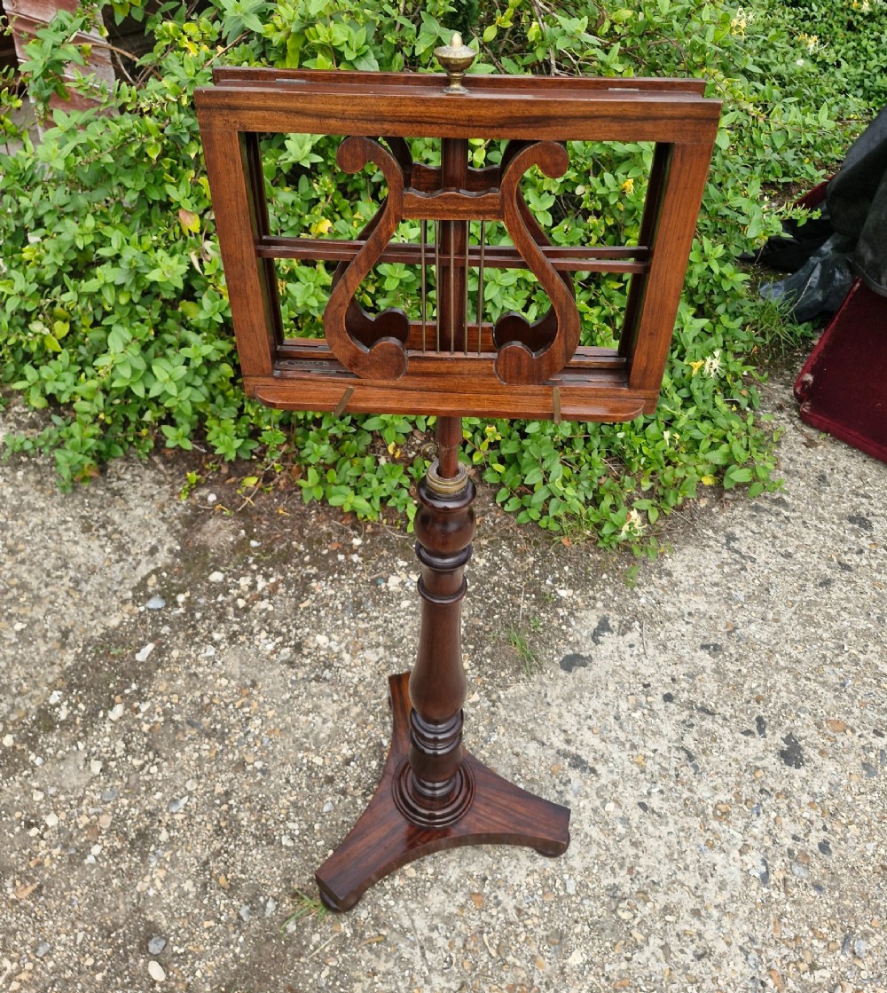 An early Victorian double-sided dark wood duet music stand featuring lyre-shaped rests and a turned pedestal column on a triform base. View III