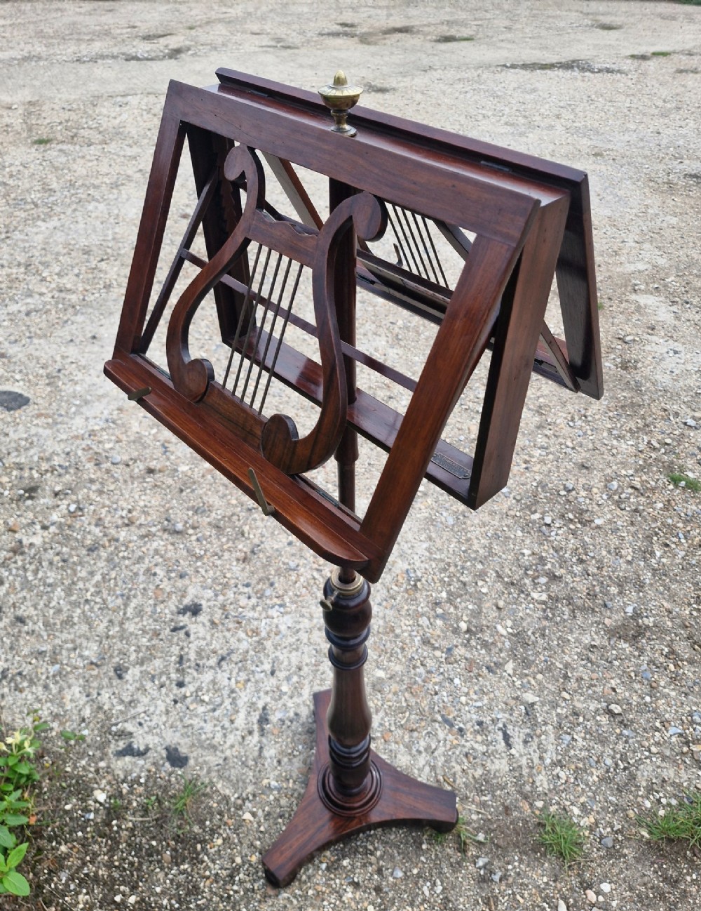 An early Victorian double-sided dark wood duet music stand featuring lyre-shaped rests and a turned pedestal column on a triform base. View IV