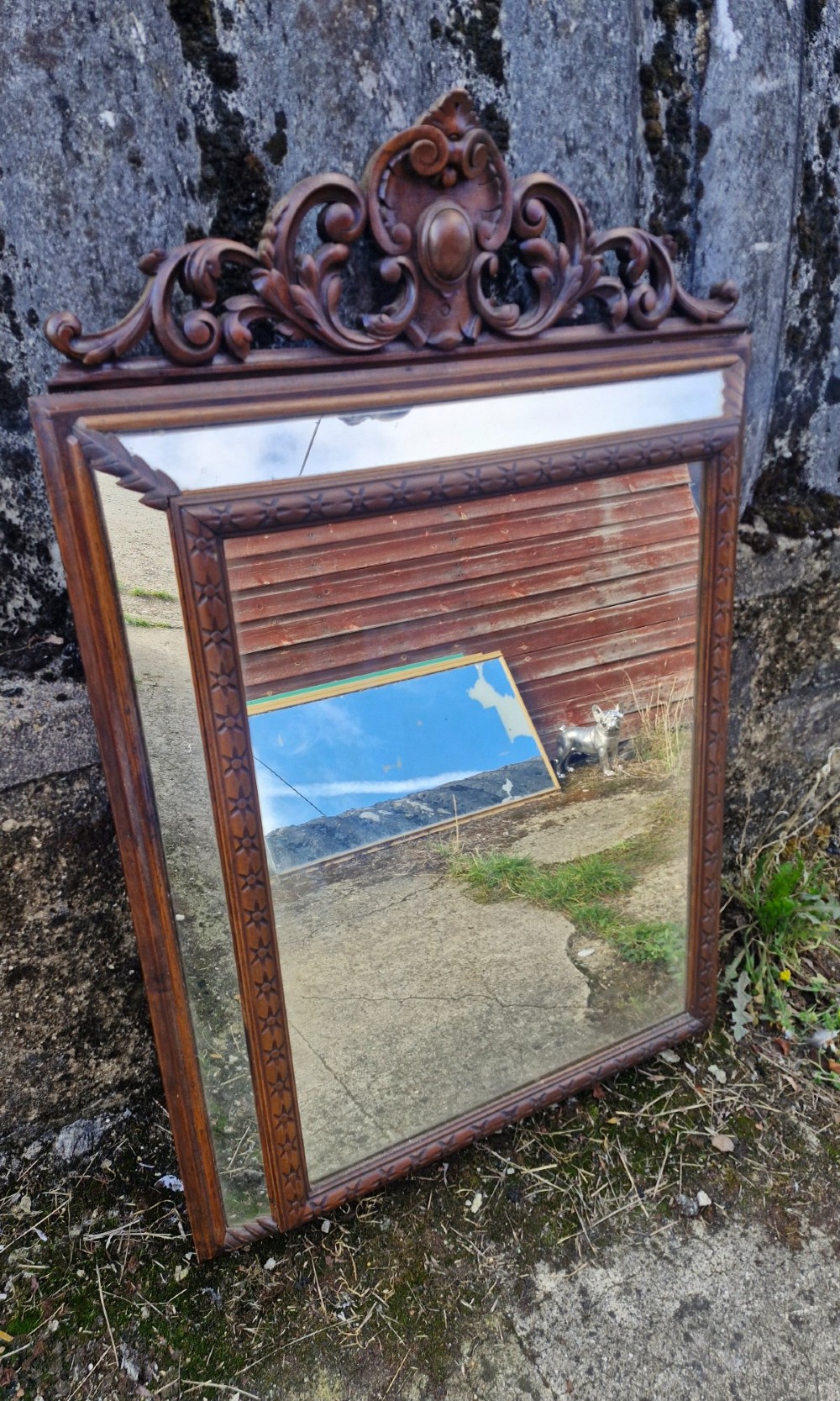 A rectangular French oak wall mirror featuring a bevelled glass plate and a pierced carved cresting with scroll motifs. View II