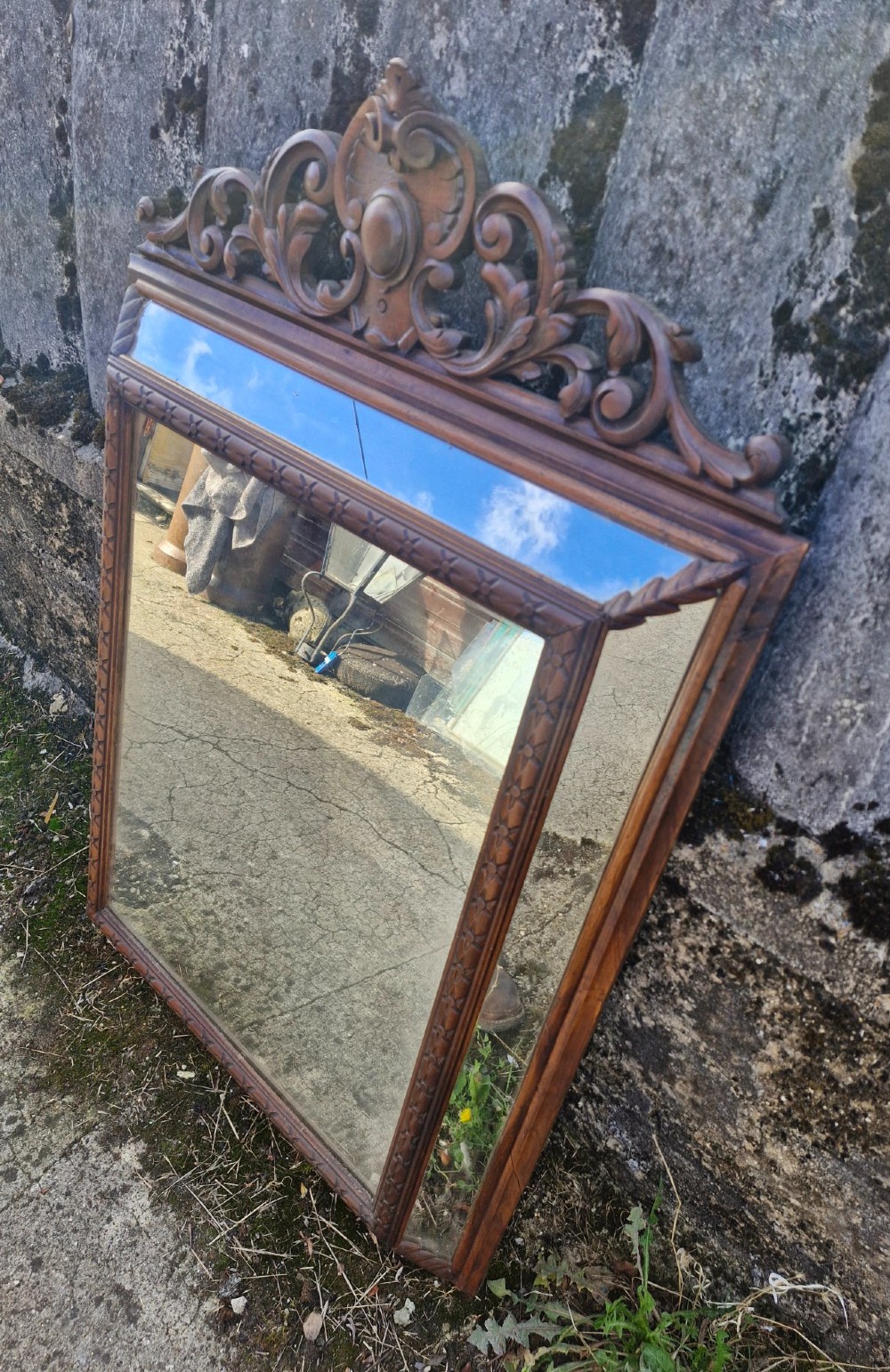 A rectangular French oak wall mirror featuring a bevelled glass plate and a pierced carved cresting with scroll motifs. View IV