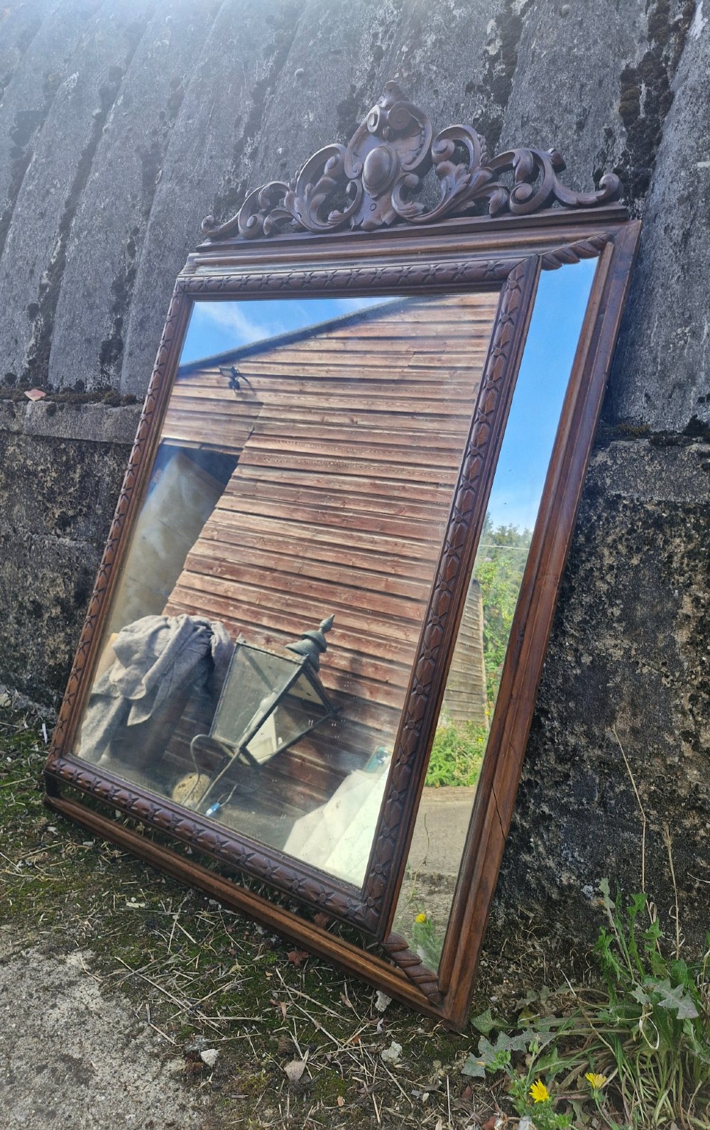 A rectangular French oak wall mirror featuring a bevelled glass plate and a pierced carved cresting with scroll motifs. View V